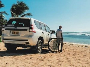 Mietwagen mit Urlauber am Strand