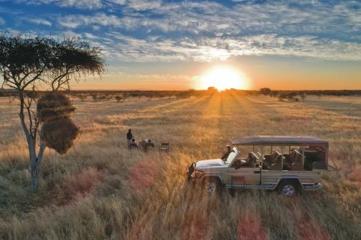 Urlauberpaar genießt den Sonnenuntergang im Etosha Nationalpark Urlauberpaar genießt den Sonnenuntergang im Etosha Nationalpark